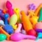 Collection de jouets sexuels colorés sur fond doux.